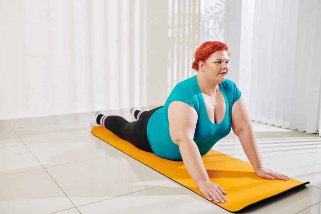 femme pratique du yoga avec la position du cobra pour aider à perdre du poids