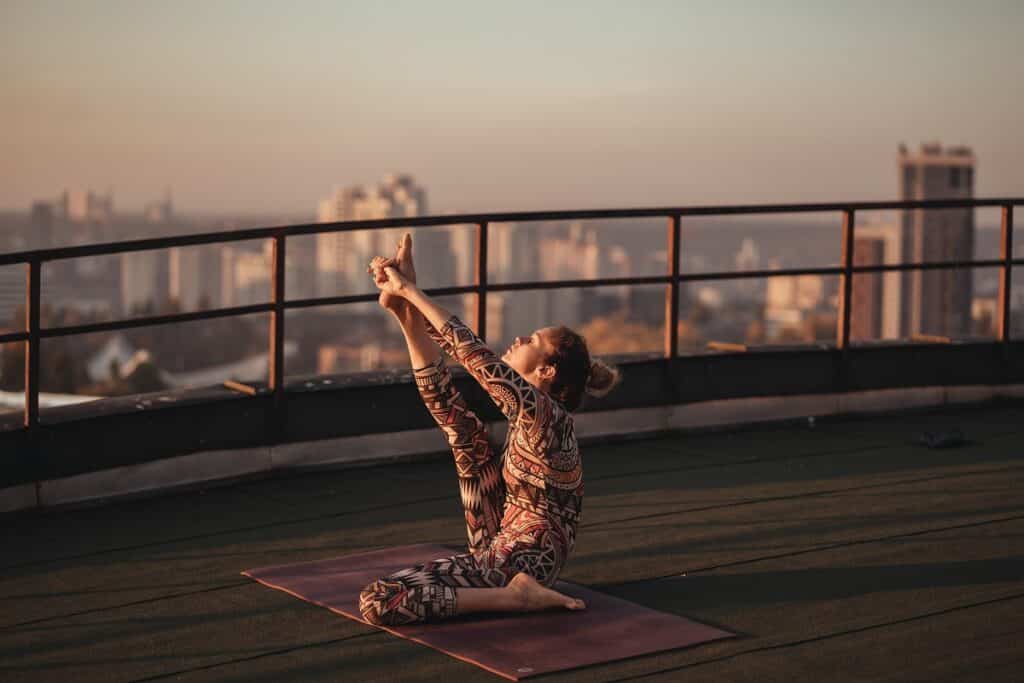 femme qui pratique le yoga sur une terrasse
