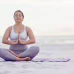 femme qui fait du yoga et méditation sur la plage